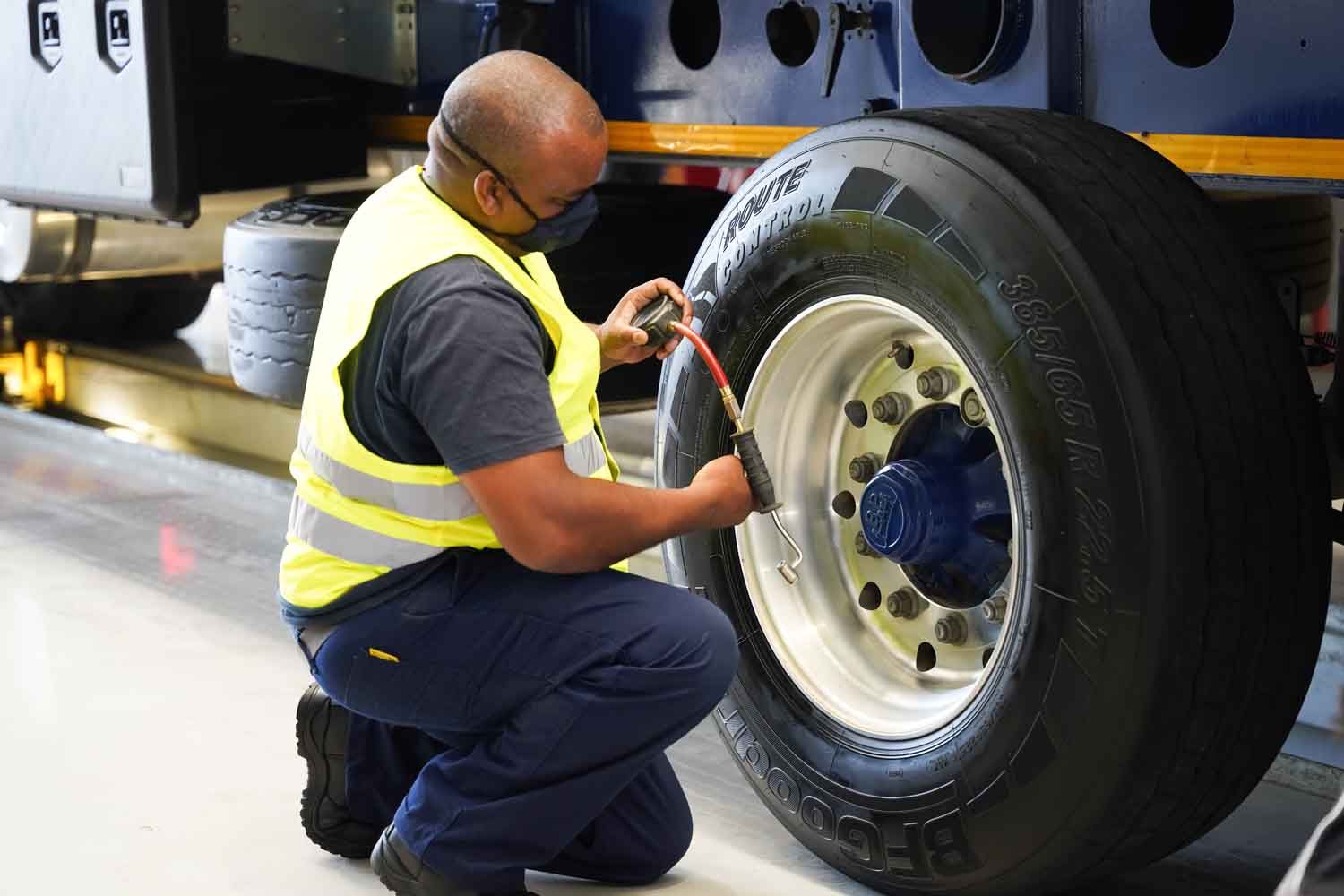Technician checking a truck tyre in the Master Cargo tyre bay